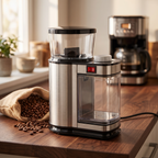 Stainless steel electric burr coffee grinder on walnut counter with bag of coffee beans