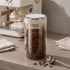 Glass vacuum coffee bean jar filled with beans on a home coffee station