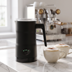Black 4-in-1 automatic milk frother on marble counter with two foamy cappuccinos