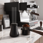 WDT needle distributor tool with stand beside a portafilter on a marble espresso bar