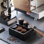 Espresso station organizer with knock box holding portafilter and tamper on a slate counter