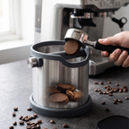 Large 2L stainless steel espresso knock box with portafilter on a concrete espresso bar